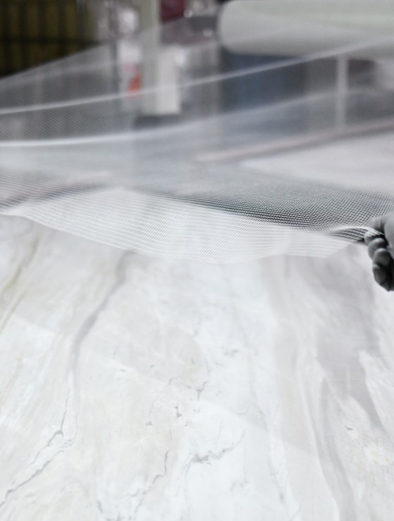 Placing a net to apply resin at a marble slab